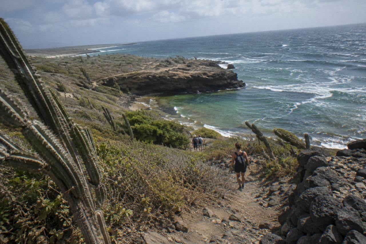 A rocky desert trail above Aruba's north-east coast leading toward a volcanic rock pool