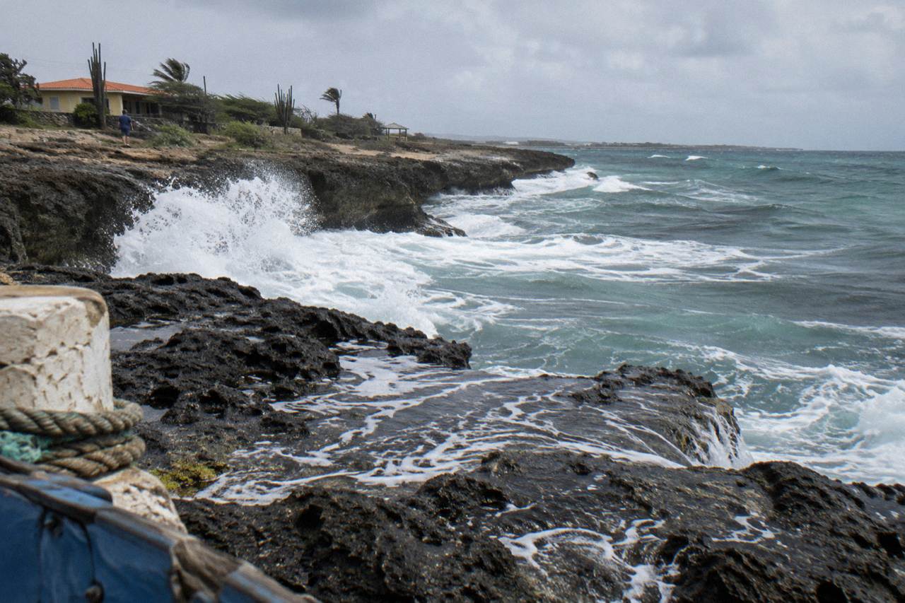 Rocky volcanic coastline with waves breaking against dark stone cliffs