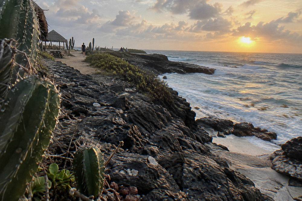 Sunrise light on volcanic rocks along a coastal footpath