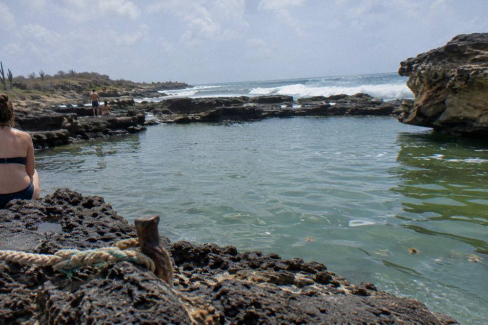 Natural rock pool basin with calm water inside a volcanic rock rim