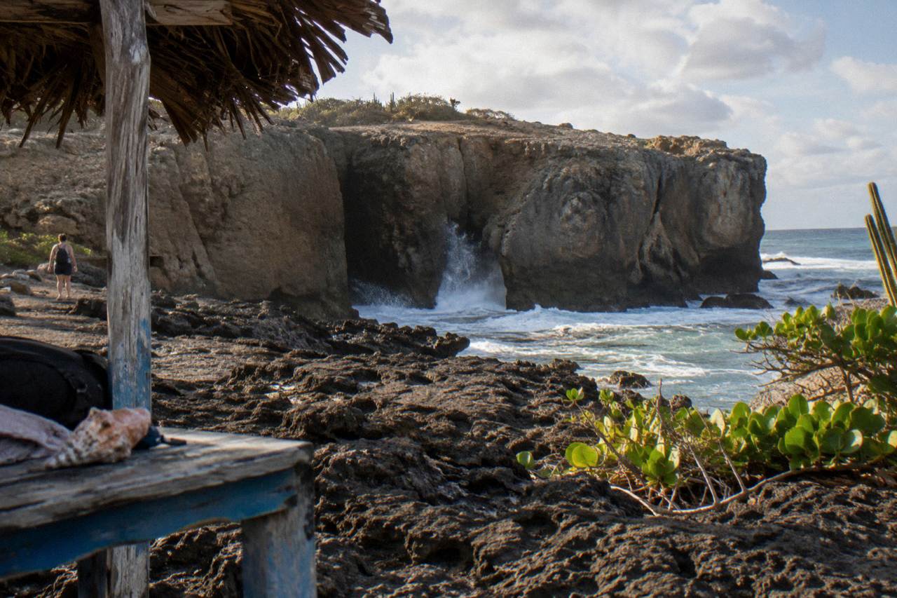 Rocky cave opening along Aruba's north coast with waves breaking beyond