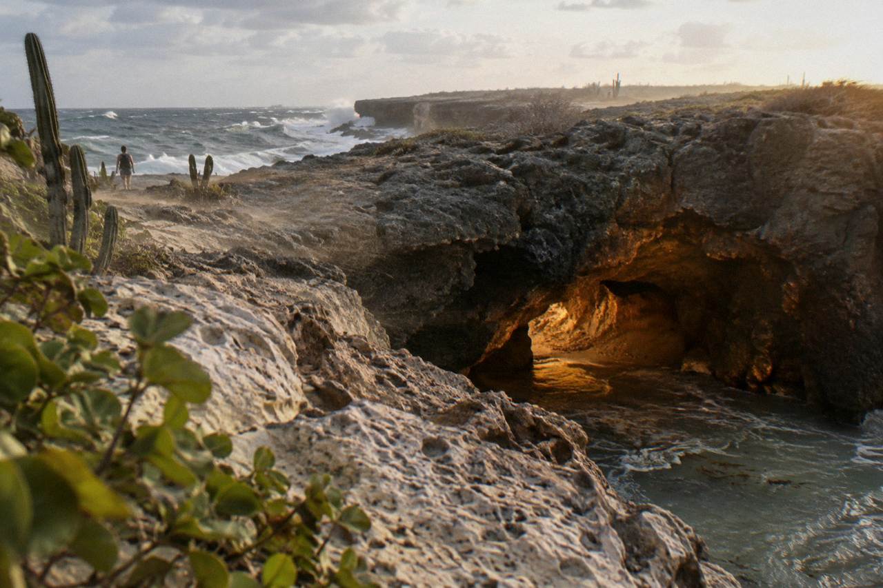Rocky cave opening along Aruba's north coast with sunlight on stone walls