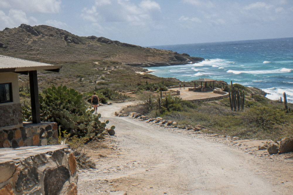 Park entrance road winding through dry landscape with rocky hills