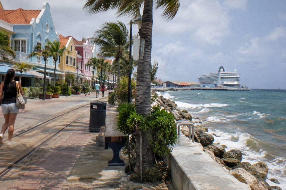 Colorful low buildings lining a sunny waterfront promenade