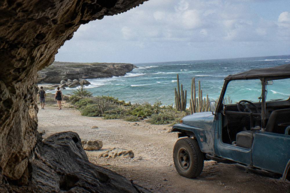 Open-air four wheel drive vehicle on a rocky desert track toward the coast