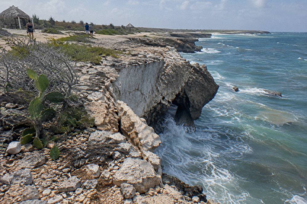 Broken limestone cliff ledge above the sea where a natural arch once stood