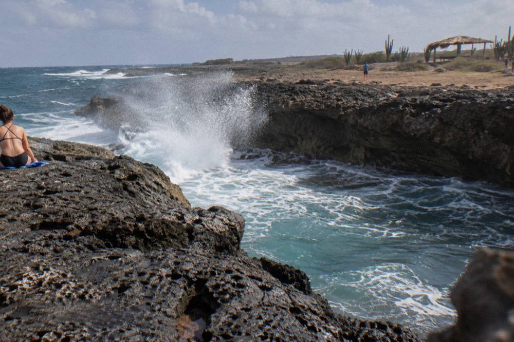 Rocky volcanic shoreline with waves breaking against dark stone cliffs
