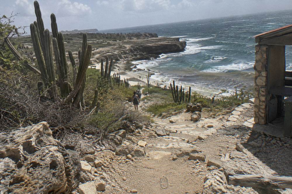 Coastal footpath across dry rocky terrain toward the sea