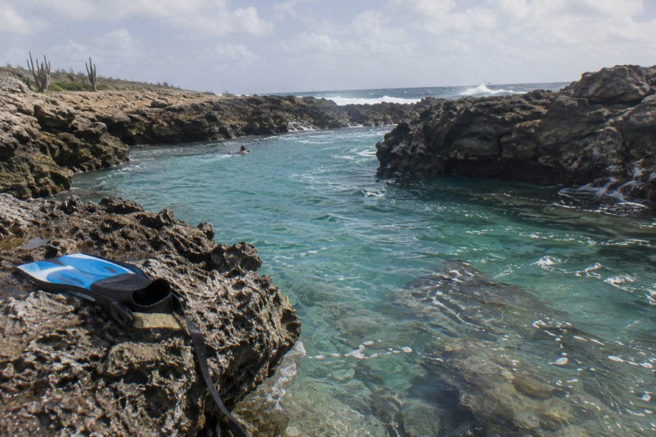 Clear turquoise water in a volcanic rock pool on Aruba's north-east coast