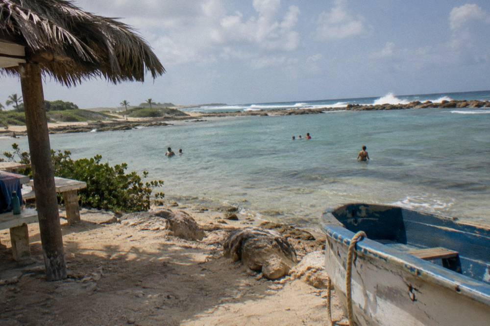 Calm protected water inside a rock basin with waves breaking white on the outer reef